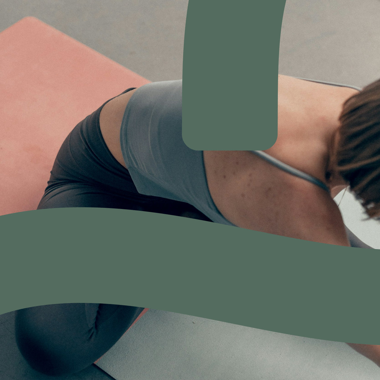 Person wearing black and gray athletic wear sitting on a pink and gray surface, partially obscured by green geometric shapes from the Bodiwealth logo, with a minimalist color-blocked background.
